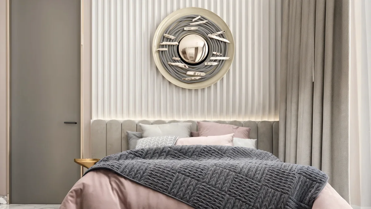 Blush bedding beneath a circular wall sculpture and softly illuminated ribbed panels