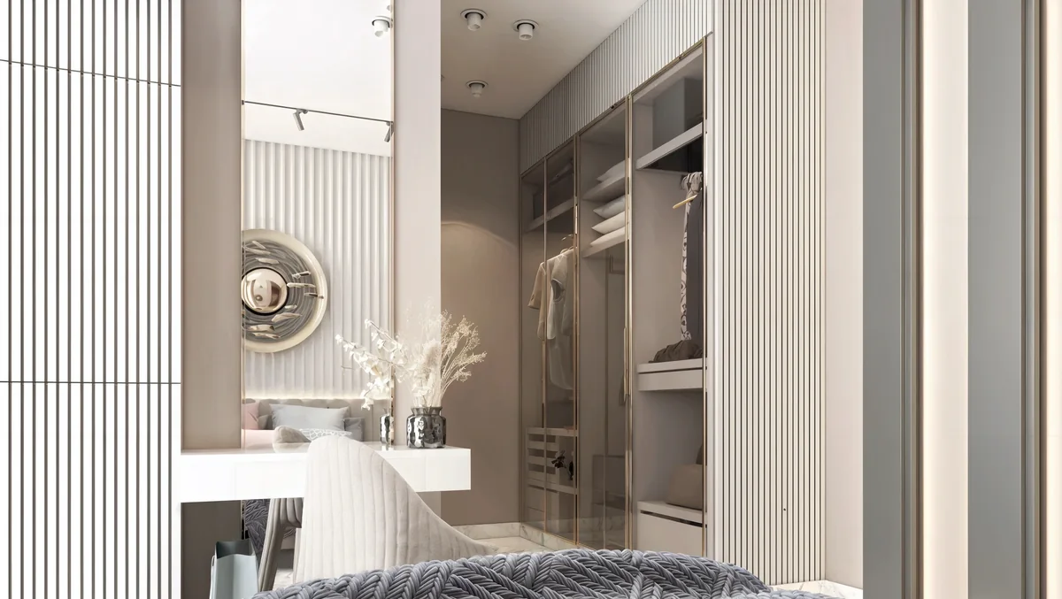 White dressing desk beside glazed wardrobes in a softly lit bedroom