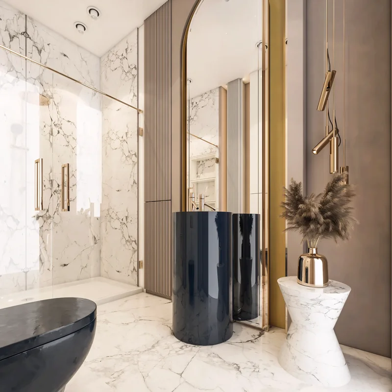Dark cylindrical basin below an arched brass-framed mirror in a marble bathroom
