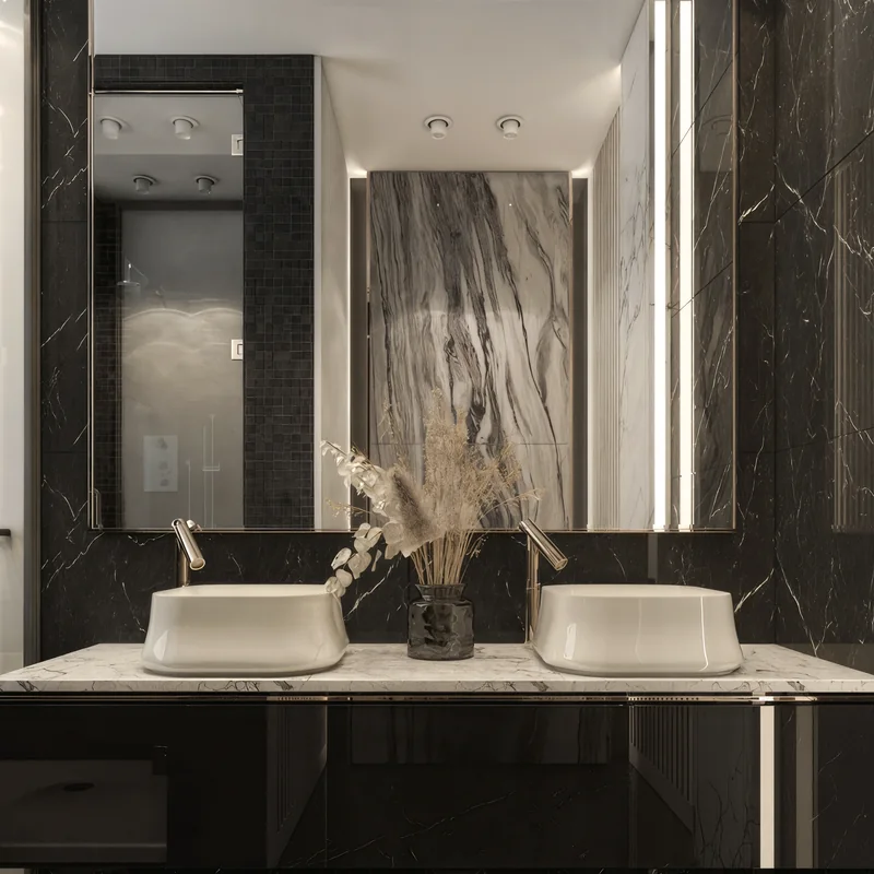 Double white basins and brass taps against black veined bathroom walls